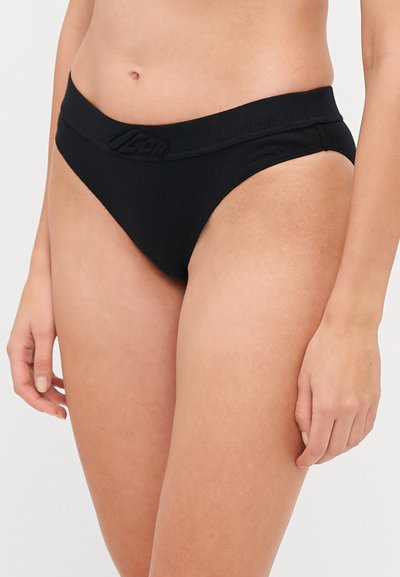 Black ribbed bikini bottom with a wide waistband featuring a textured logo detail. The design is minimal and classic, emphasizing comfort.