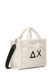 Borsa a spalla in pelliccia color crema con dettagli in logo nero. Presenta manici corti e una tracolla nera rimovibile. Materiale morbido e strutturato.