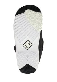 Black and white sneaker sole with textured grips, a white rubber patch, and DC logo at the center of the sole.