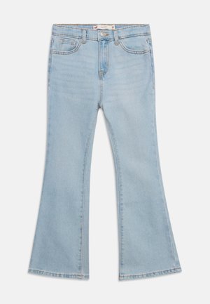 Lichtblauwe spijkerbroek met hoge taille, vooraan knoop- en ritssluiting, en uitlopende pijpen, plat gelegd op een witte achtergrond.