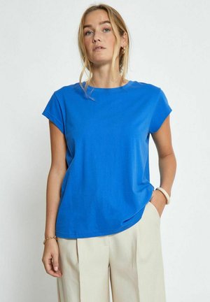 Blaues Kurzarm-T-Shirt aus weicher Baumwolle mit Rundhalsausschnitt, in entspannter Passform und glatter Textur. Kombiniert mit hellen Hosen.