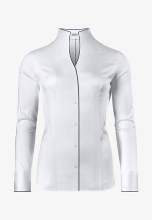 Chemise blanche à manches longues avec un col haut, dotée d'une fermeture à boutons sur le devant et de passepoils navy le long de l'encolure et des poignets. Texture lisse.