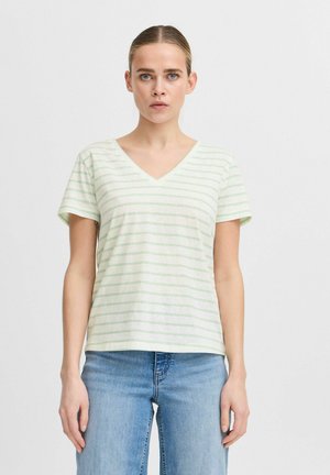Camiseta de manga corta a rayas en verde claro y blanco, hecha de un tejido suave. Con un corte holgado y dobladillo recto. Combinada con jeans azules.