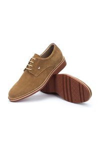 Chaussures en daim marron avec une finition lisse, bout rond et cinq œillets pour les lacets. Semelle en caoutchouc texturé avec un motif de crampons.