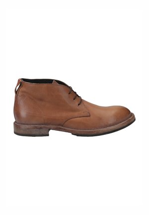 Bottes de cheville en cuir marron avec un fini lisse, bout arrondi et semelle contrastante. Elles disposent de lacets fins et d'une petite boucle au niveau du talon.