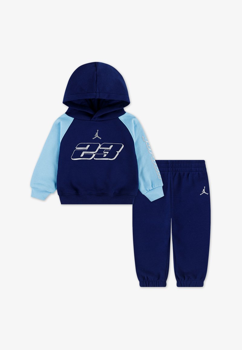 Navy blue hoodie with light blue sleeves, featuring "23" logo and Jordan emblem. Matching navy joggers with cuffed ankles and logo.
