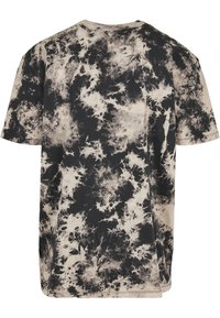 Kortermet T-skjorte i bomull med et svart og beige tie-dye mønster. Løs passform med rund hals og dobbelt søm i kantene.