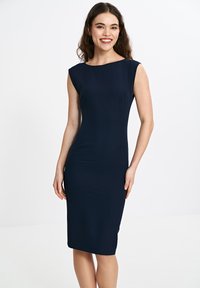 Granatowa, dopasowana sukienka z dekoltem łódkowym, bez rękawów i gładkiego materiału. Posiada długość do kolan i subtelne szwy boczne.