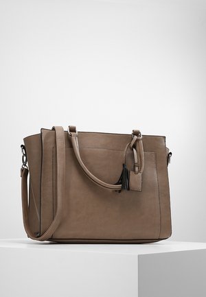 Brązowa skórzana torebka z podwójnymi uchwytami, odpinanym paskiem na ramię oraz małym zawieszką w formie chwostu, umieszczona na białej powierzchni ekspozycyjnej.