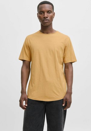 Gelbes T-Shirt mit kurzen Ärmeln, rundem Halsausschnitt und lässiger Passform. Der Stoff wirkt weich und hat eine leichte Textur; kombiniert mit dunklen Hosen.