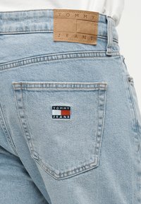 Φωτεινά μπλε τζιν τζιν με ταμπά δερμάτινο έμπλαστρο με την ένδειξη "TOMMY JEANS" και πολύχρωμο λογότυπο στην πίσω τσέπη. Κανονική εφαρμογή.