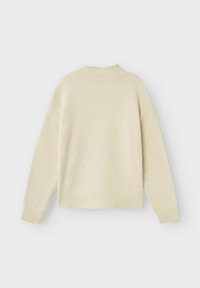 Maglione a maglia color crema con scollatura rotonda, spalle scese e polsini a coste sulle maniche e sull'orlo. Texture morbida, design minimale.