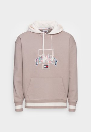 Savanninruskea huppari valkoisilla nauhoilla, etutaskulla, raidallisilla resoreilla ja monivärisellä "TOMMY"-logolla sekä "Tommy Jeans" -etiketillä rinnassa.