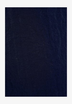 Tessuto blu navy con un aspetto leggermente testurizzato e intrecciato. Contiene piccole particelle di pelucchi, che indicano un materiale in cotone o misto.
