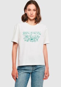 Hvid bomulds t-shirt med korte ærmer, der har et turkist blomstret grafisk tekstdesign "SPRING AWAKENING" foran.