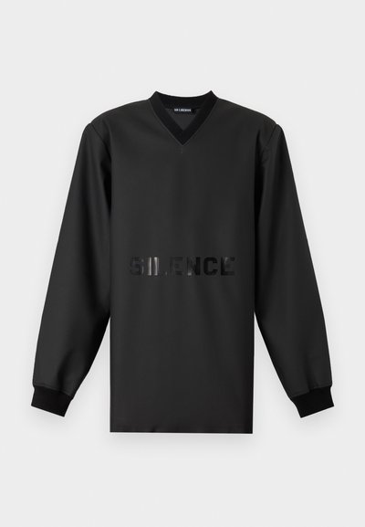 Sweatshirt noir à col V, à manches longues, avec un texte brillant "SILENCE" sur la poitrine. Tissu lisse et poignets côtelés.