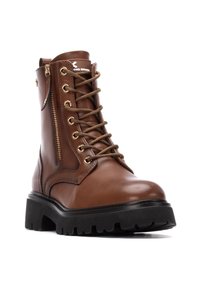 Botas de cuero marrón con cordones, herrajes dorados, cremallera lateral, suela texturizada y una plataforma negra gruesa. Presentan costuras reforzadas y marca.