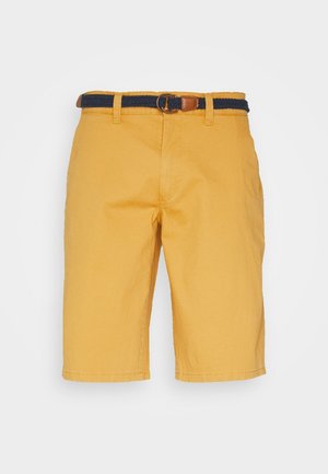 Pantaloni corti gialli in cotone con taglio dritto, dotati di una cintura intrecciata blu navy con fibbia in pelle marrone. Inclusi tasche laterali e tessuto morbido.