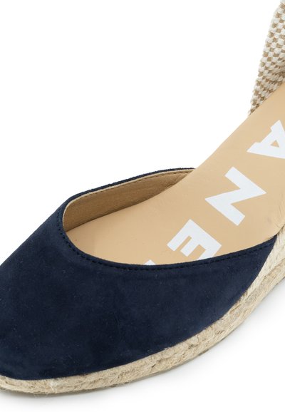 Marineblaue Wildleder-Espadrilles mit runder Zehe, gewebten Stoffakzenten und Sohle aus Jute. Die Innensohle zeigt ein weißes Markenlogo.