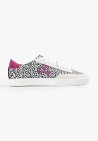 Sneakers z białą cholewką z czarnym kropkowanym wzorem, różowym zamszowym obcasem i fioletowym akcentem w postaci czaszki i piszczeli. Płaskie białe sznurowadła.