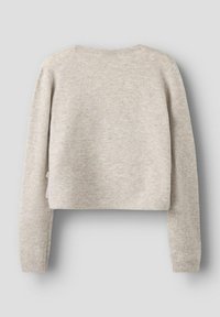 Kratka pulover iz svetlo bež pletenine. Ima dolge rokave in okroglo izrez. Tekstura z manjšimi odstopanji v barvi.