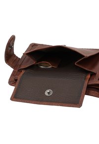 Brown leather wallet open, showing empty coin compartment with snap button and a single coin inside.