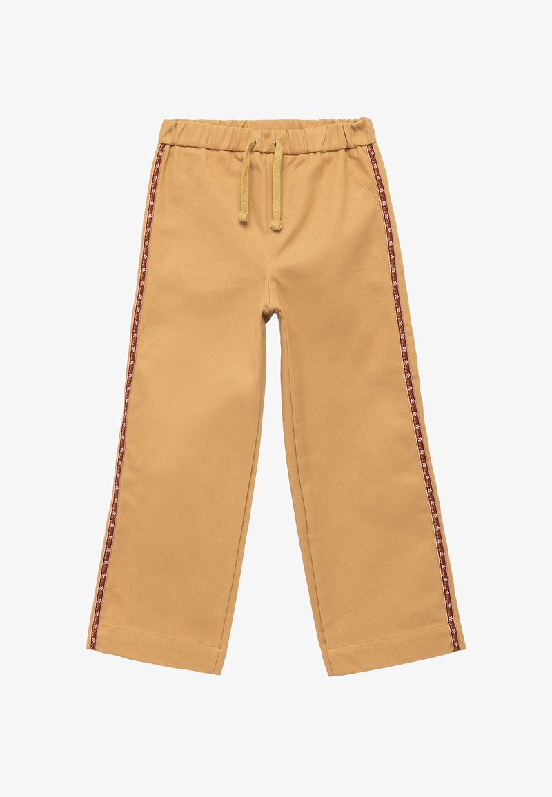 Pantalons en coton beige avec une taille élastique et un cordon de serrage. Une rayure à motifs rouges et blancs court sur le côté. Design à jambes larges.