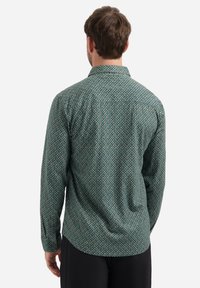 Groene langemouwen shirt van textuurstof, met een klein, herhalend geometrisch patroon en een klassiek kraagontwerp.