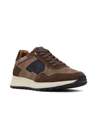 Sneaker in suede marrone con accenti blu navy, superfici texture, lacci rotondi e suola in gomma nera con battistrada. Presenta un design a profilo basso.