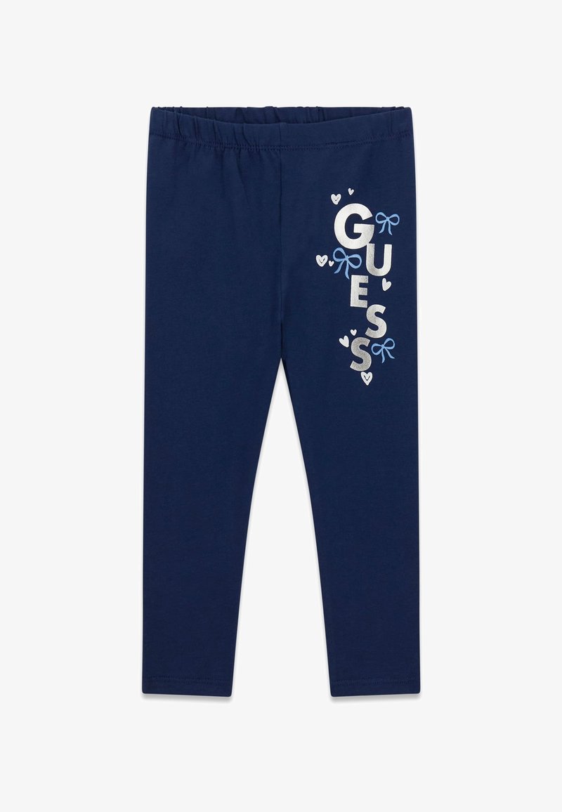 Leggings bleu marine avec taille élastique, ornés de textes "GUESS" blancs et bleus, petits cœurs et illustrations de nœuds bleus sur la jambe droite.