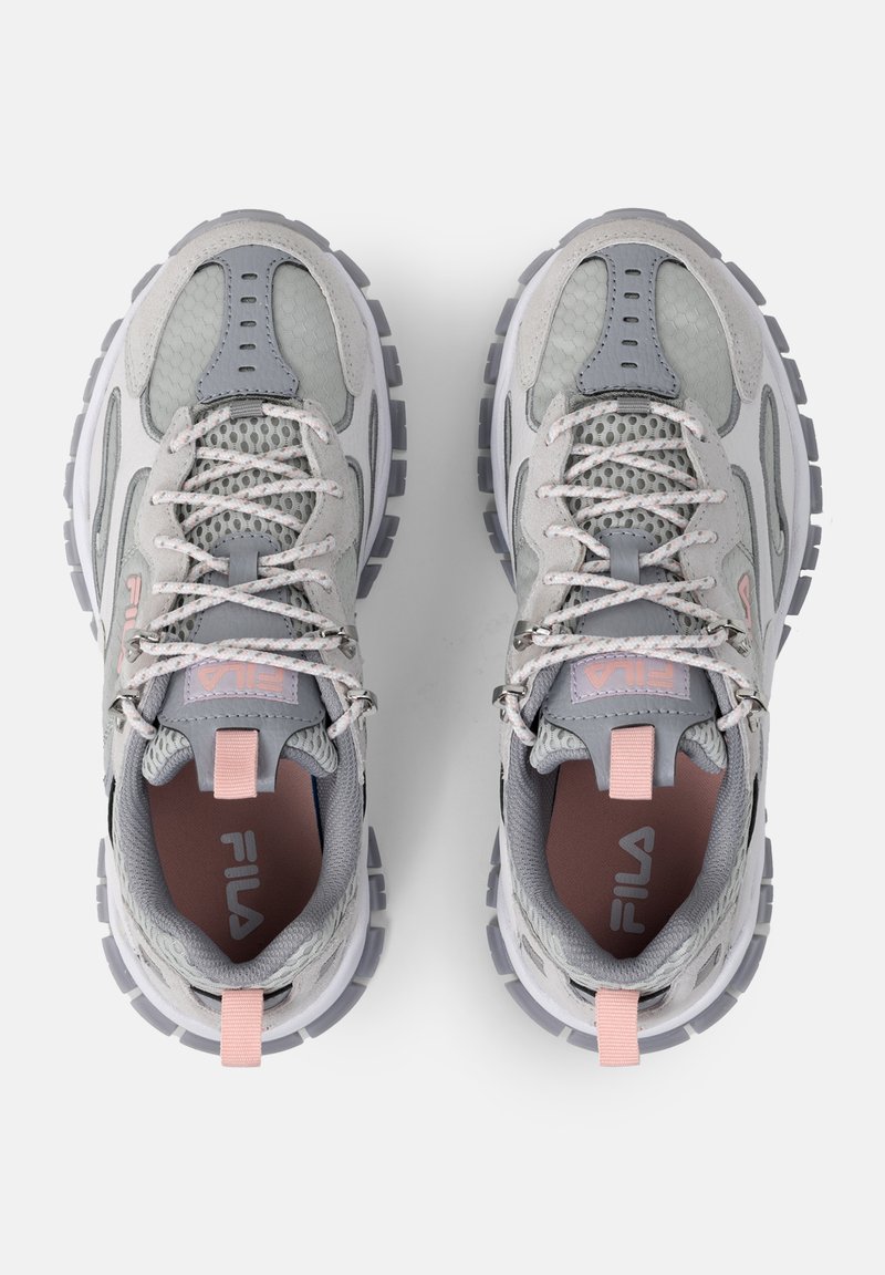 Baskets grises et blanches avec une tige en mesh et en suède, des accents roses, une semelle texturée et un design à lacets.