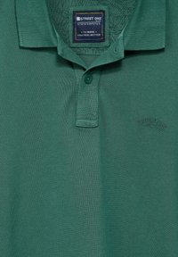 Zelená polokošile vyrobená z texturované tkaniny se třemi knoflíky. Na prsou má vyšívané logo "STREET ONE".