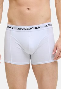 Valkoiset puuvillabokserit, joissa on musta elastinen vyötärö, jossa on "JACK & JONES" -logo. Sileä pinta ja istuva muotoilu.