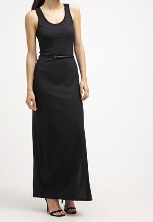 Robe maxi noire avec encolure dégagée, coupe ajustée et taille ceinturée. Tissu lisse et léger, associée à des sandales à talons hauts noires.