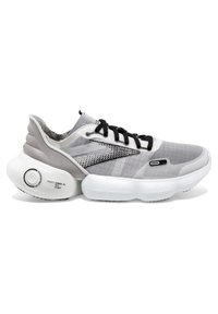 Scarpa sportiva grigia con tomaia in rete, lacci neri, suola bianca arrotondata e dettaglio circolare di pompaggio. Presenta una superficie texturizzata e accenti laterali.