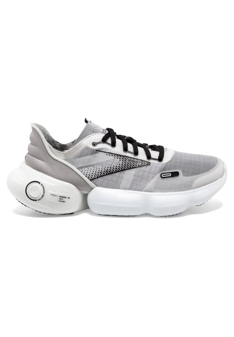 Scarpa sportiva grigia con tomaia in rete, lacci neri, suola bianca arrotondata e dettaglio circolare di pompaggio. Presenta una superficie texturizzata e accenti laterali.