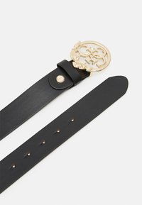 Zwarte leren riem met een ronde goudkleurige gesp met een logo en laurierontwerp. De band heeft verschillende gaatjes voor maatregulering.