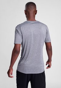 Szary T-shirt z krótkim rękawem, wykonany z miękkiego materiału, z okrągłym dekoltem i standardowym krojem, charakteryzujący się gładką strukturą bez wzorów.
