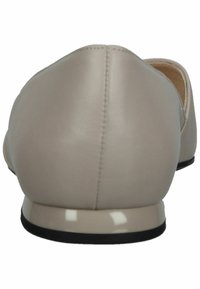 Ballerines en cuir beige avec un bout rond, une texture lisse, des détails de couture subtils et une semelle en caoutchouc noir.
