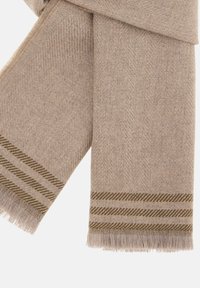 Beige uld scarf med et fiskebensmønster og grønne stribede detaljer i enderne. Frynserne i kanterne tilføjer tekstur.