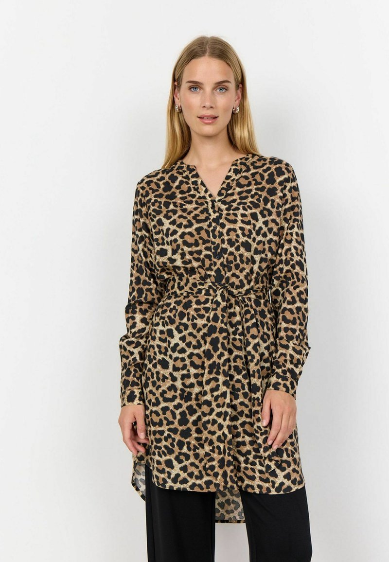 Leopardmönstrad omslagsklänning i mjukt tyg, med V-ringning, långa ärmar, knytmidja och sidoklyvor. Basfärgen är beige med svarta fläckar.