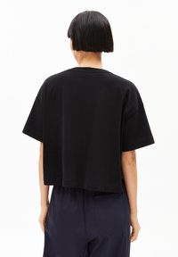 Black, short-sleeve t-shirt with a loose fit and crew neck, featuring smooth cotton material and a cropped hemline.