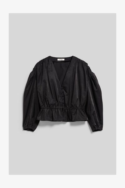 Blouse noire à manches longues avec col en V, boutonnée devant, taille froncée et épaules bouffantes, posée à plat sur fond gris.
