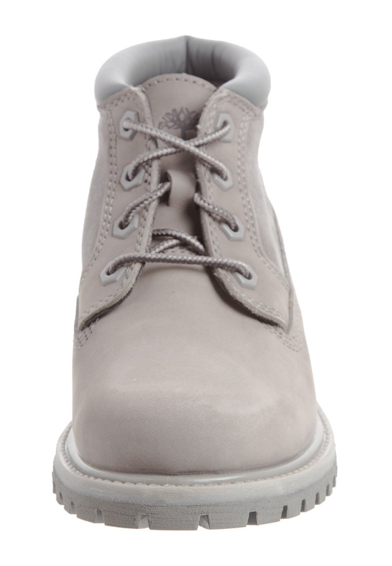 Bottine en cuir gris avec un bout rond, surface texturée, œillets en métal et lacets gris. Semelle plate en caoutchouc avec un motif de semelle prononcé.