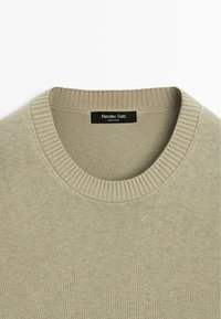 Lichtgroene trui met een geribde ronde hals. Heeft een gladde textuur en een label met de tekst "Massimo Dutti" aan de binnenkant.