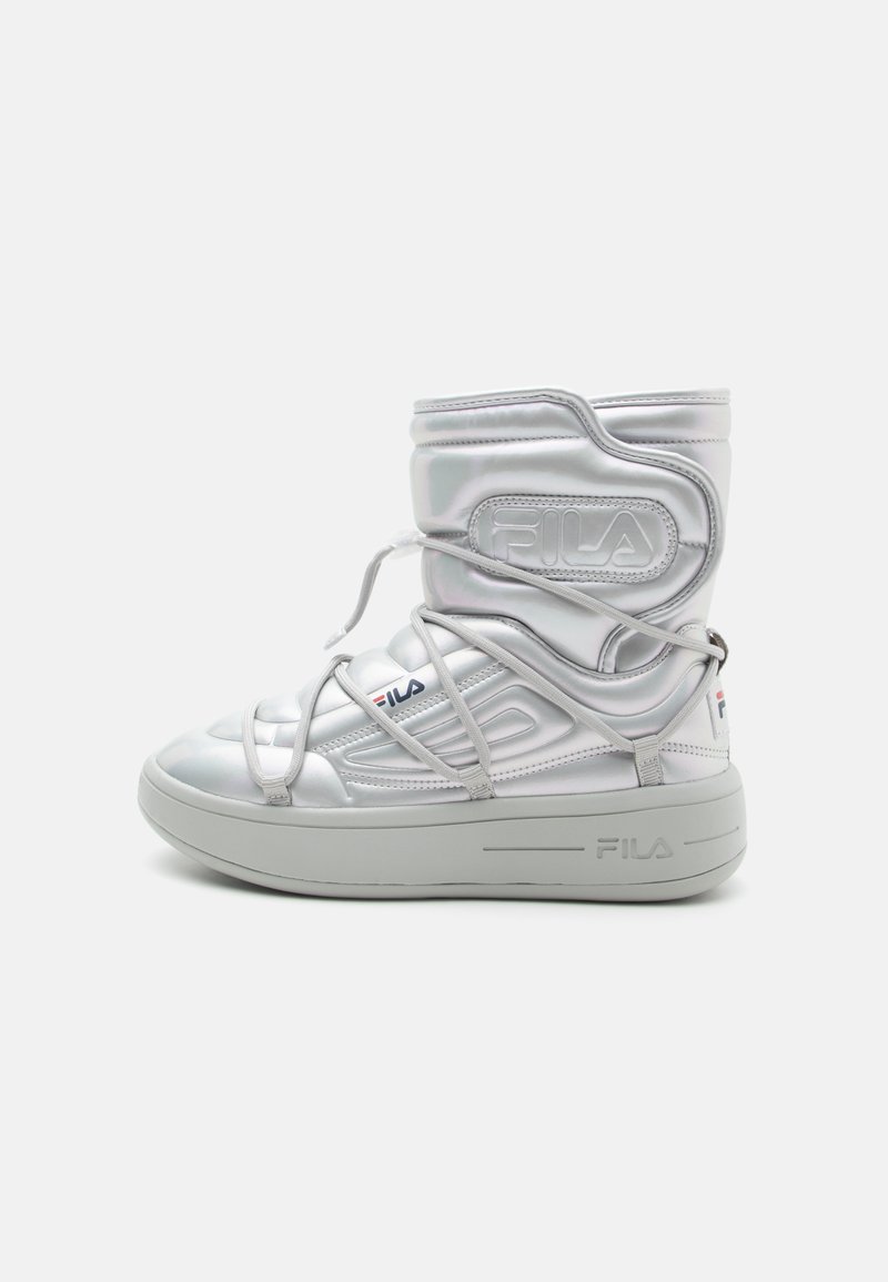 Hvit høy-topp sneakers laget av blankt materiale med synlig søm og tykk såle. Har snøringer og 'FILA' merkevare på siden.