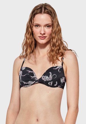 Top de bikini negro con diseño de escote pronunciado, que presenta patrones de estampado de leopardo en blanco. Tirantes ajustables con una textura suave.