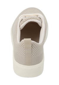 Sneaker lavorato a maglia color beige con suola bianca, colletto imbottito, maniglia nella parte posteriore e texture di tessuto traspirante visibile, vista dall'alto.
