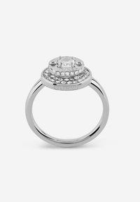 Anello in argento con un diamante rotondo centrale circondato da pietre più piccole, con tre bande sovrapposte e il nome del marchio inciso di lato.