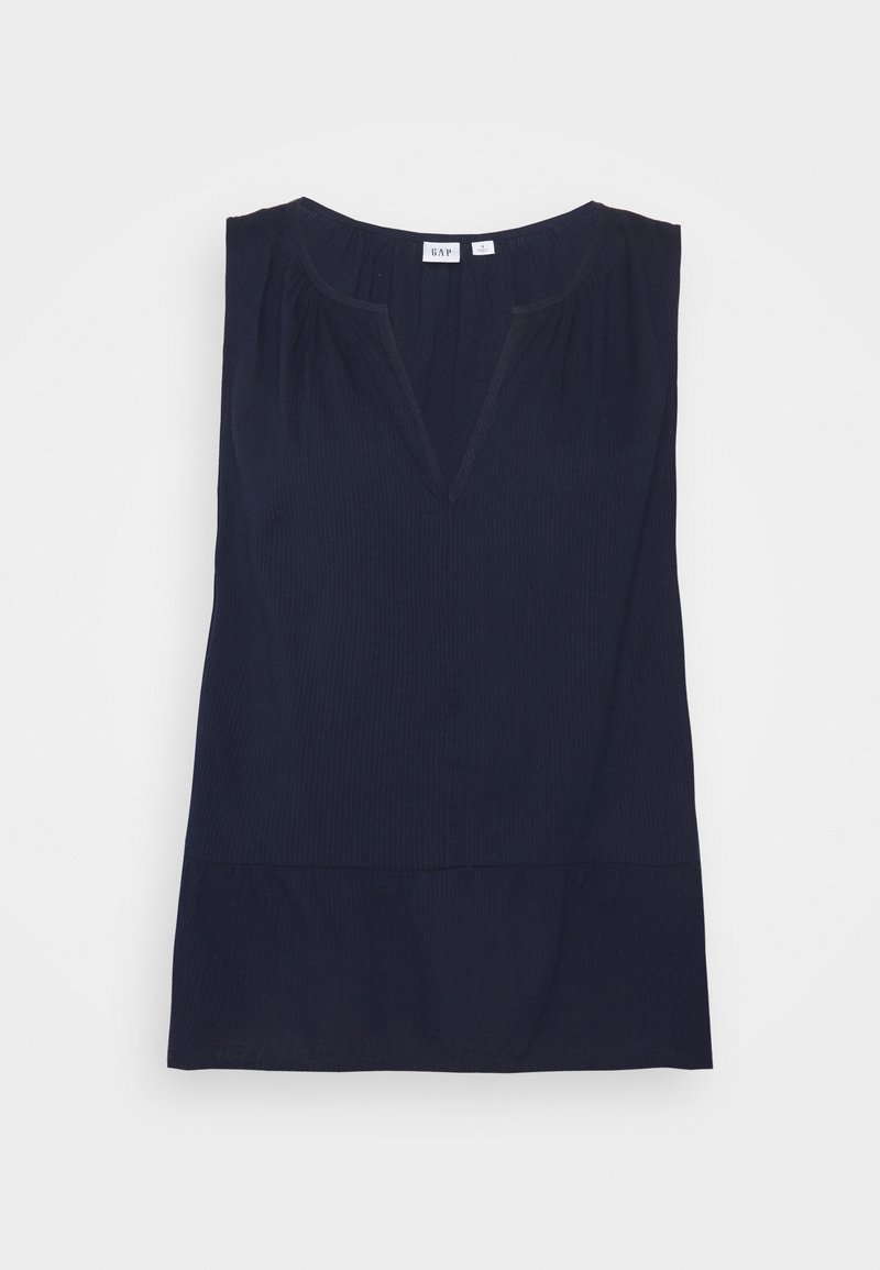 Blouse sans manches bleu marine avec de subtils plis, encolure en V et détail froncé aux épaules, posée à plat sur fond blanc.